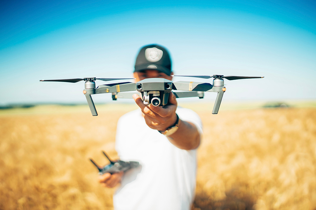 Man holding a drone near field. 