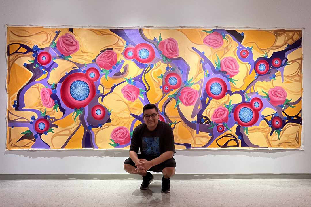 Indigenous USask graduate Brody Burns (BA'21, MFA'23) is seen in front of his canvas painting entitled, James Smith from his summer MFA exhibition, No Words Necessary. (Submitted photo)