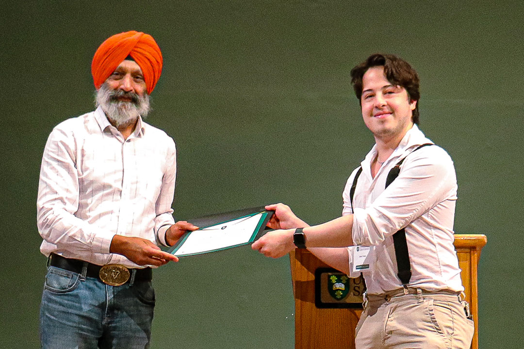 Dr. Baljit Singh, Vice President, Research, handing an award to Ariel Tirado. (Photo: Submitted)