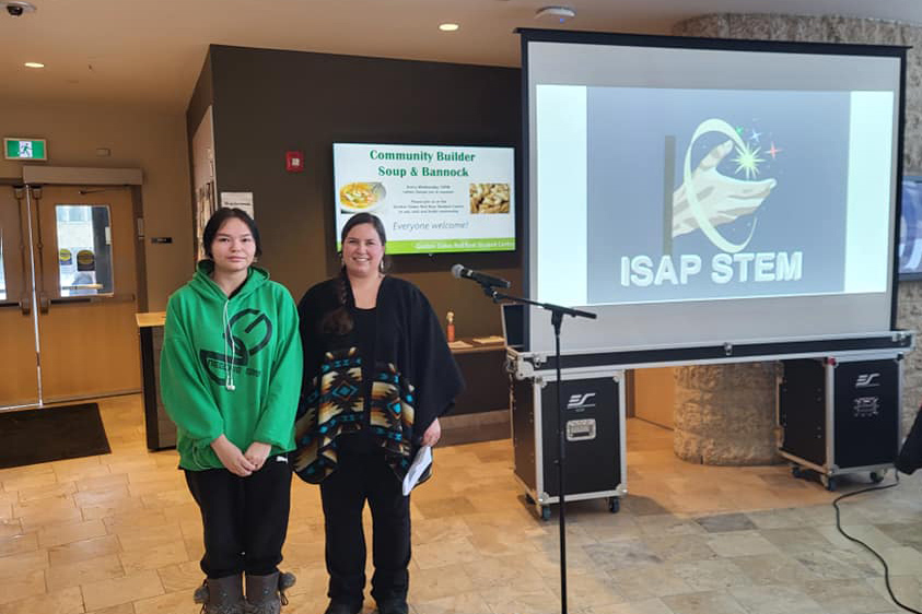 Student artist Tia McCallum and Sarah Gauthier present the new graphic design for ISAP STEM+. 