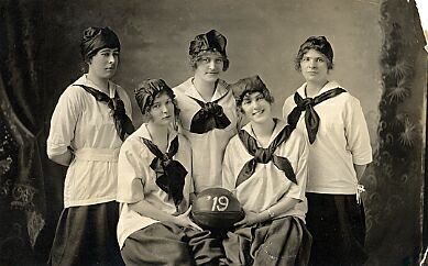 Basketball Huskiettes “Champion Girls” in uniform. The players are E. Hart, L. Eyrikson, A. Staples, B. Bridgeman, M. Buttery. The basketball has “19” marked on it, representing the year these players expected to graduate. (Photo: University Archives and Special Collections, A-925)