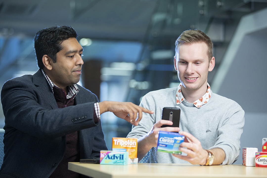Researchers Debajyoti Mondal (left) and Alexander Magnus designed an app for “translating” medicine labels.  (Photo Credit: Dave Stobbe for the University of Saskatchewan.)