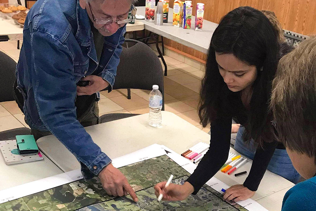 SENS Indigenous mentor Anthony Johnston (top left) and student Anuja Thapa (top right) examines maps of Mistawasis Nêhiyawak. (Photo: Submitted)