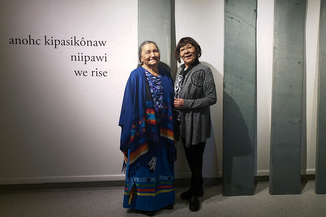 Elders Evelyn Linklater (left) and Florence Highway stand next to the reclaimed stone steps that will be etched with Cree syllabics during Indigenous Achievement Week. (Photo: Vanessa Hyggen)