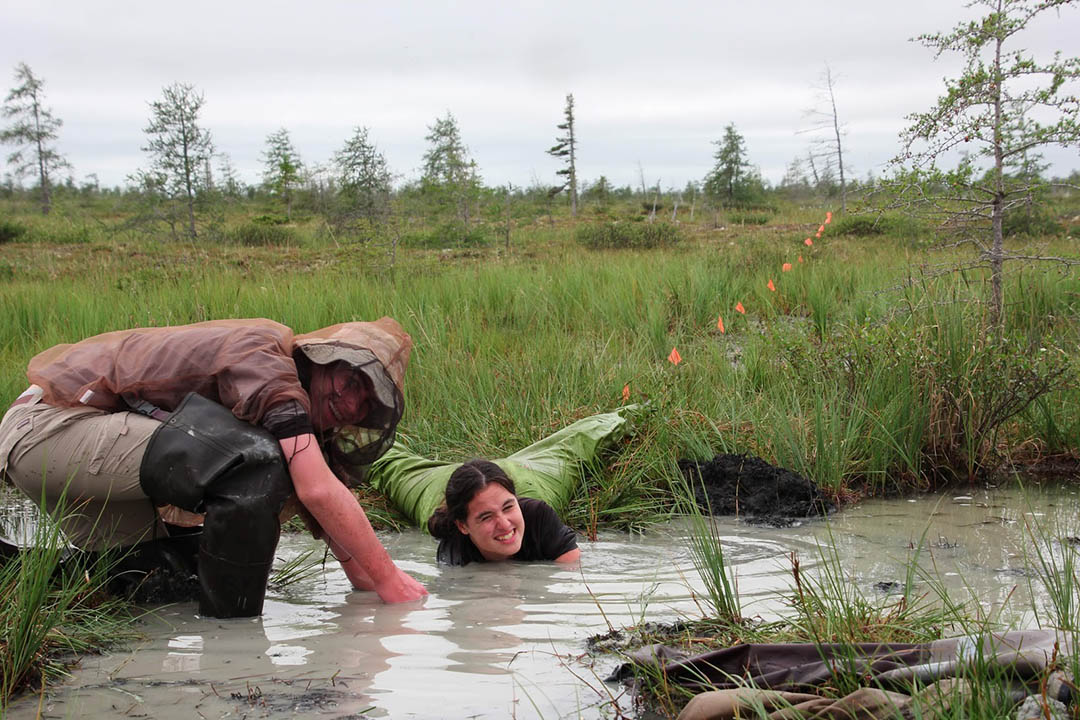 A high school student from Churchill, Man. reaches down to touch the permafrost beneath a pond in Wapusk National Park (Photo: Ryan Brook)