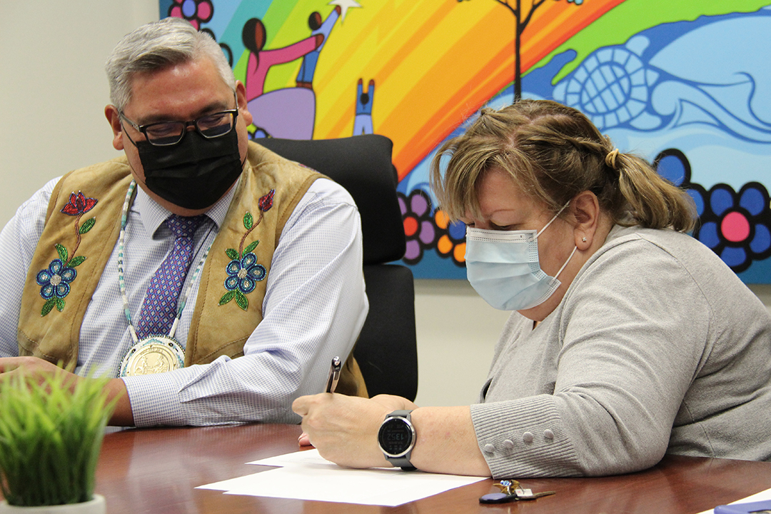 Dr. Alexandra King, right, signs the Memorandum of Understanding. (Photo: Kristen McEwen)