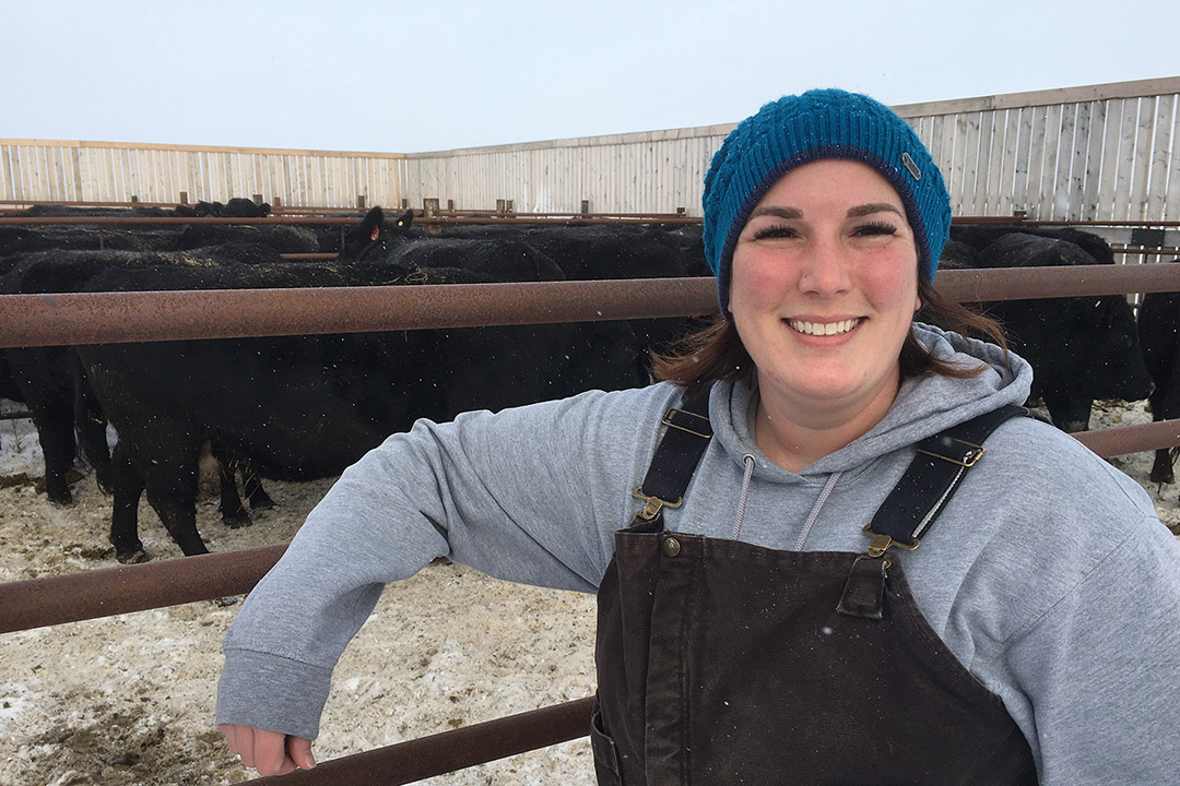 USask PhD student Rachel Carey in front of the pen with bred cows at the Livestock and Forage Centre of Excellence near Clavet. (Photo: Lana Haight)