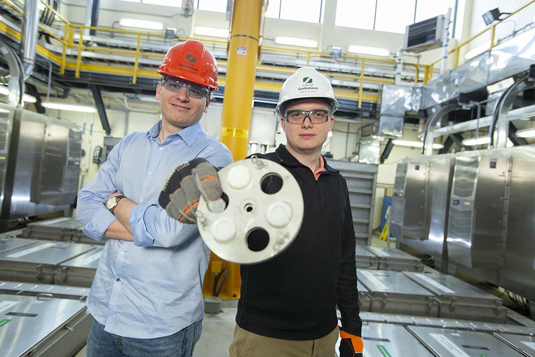 City of Saskatoon wastewater treatment plant manager Mike Sadowski (right), with USask toxicologist Markus Brinkmann (left), holds up a wastewater sampling device in February, 2020. (Photo: David Stobbe)