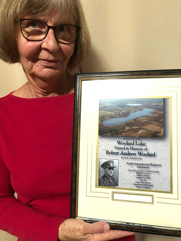 Helen Woolard McPhail holds a plaque honouring her late uncle Lieutenant Robert Woolard, who died at Dieppe during the Second World War. A lake north of Meadow Lake is named in his honour. (Photo: Courtesy of Helen Woolard McPhail)