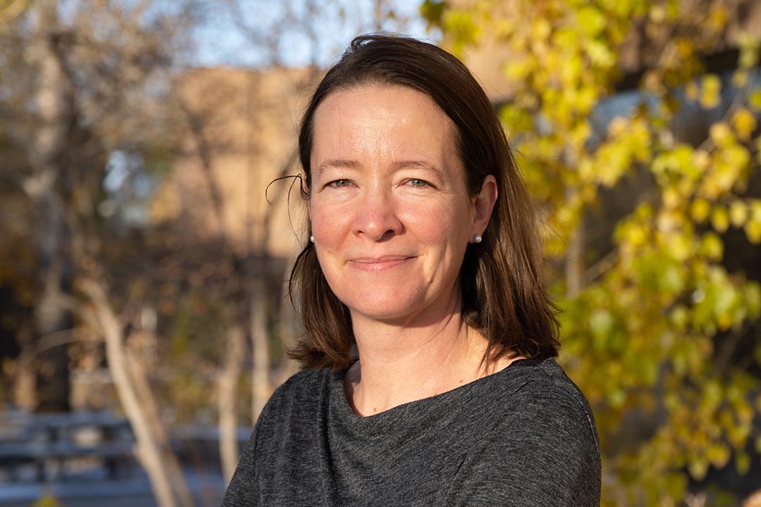 Kimberly Gilmour outside near a pond in winter.