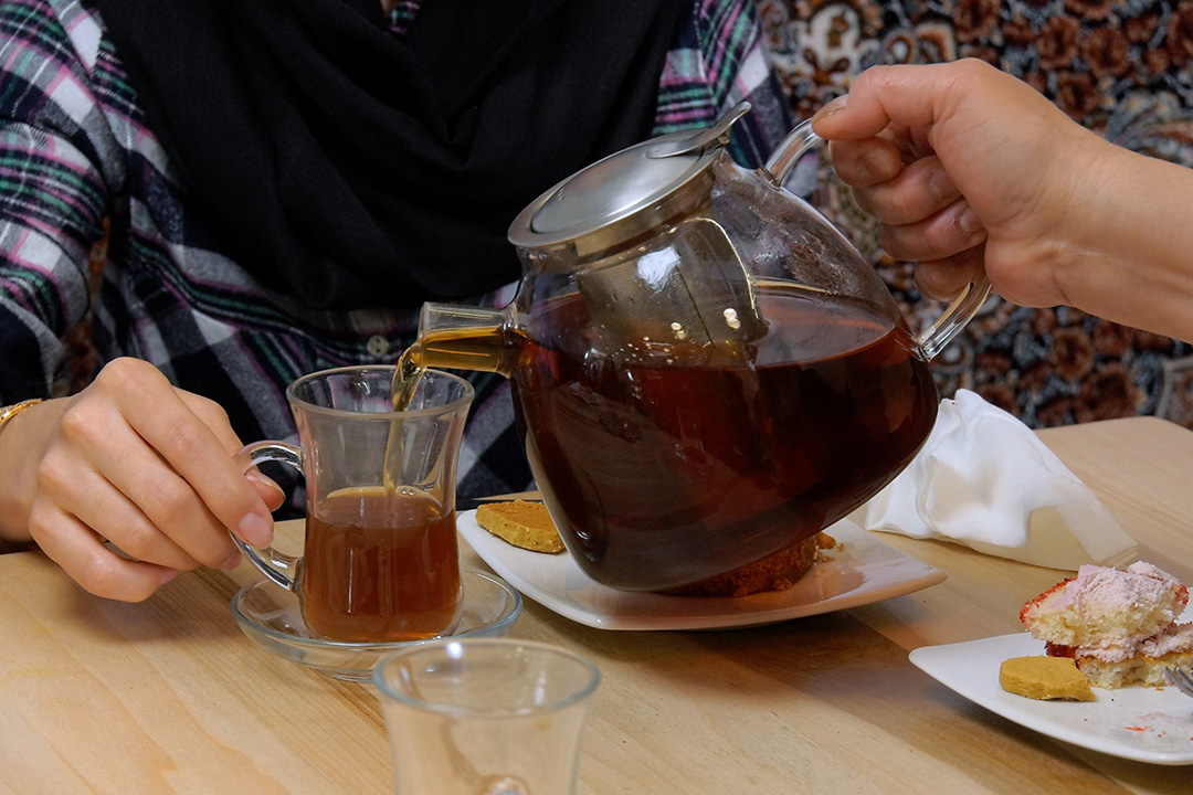 Image of hands pouring tea.