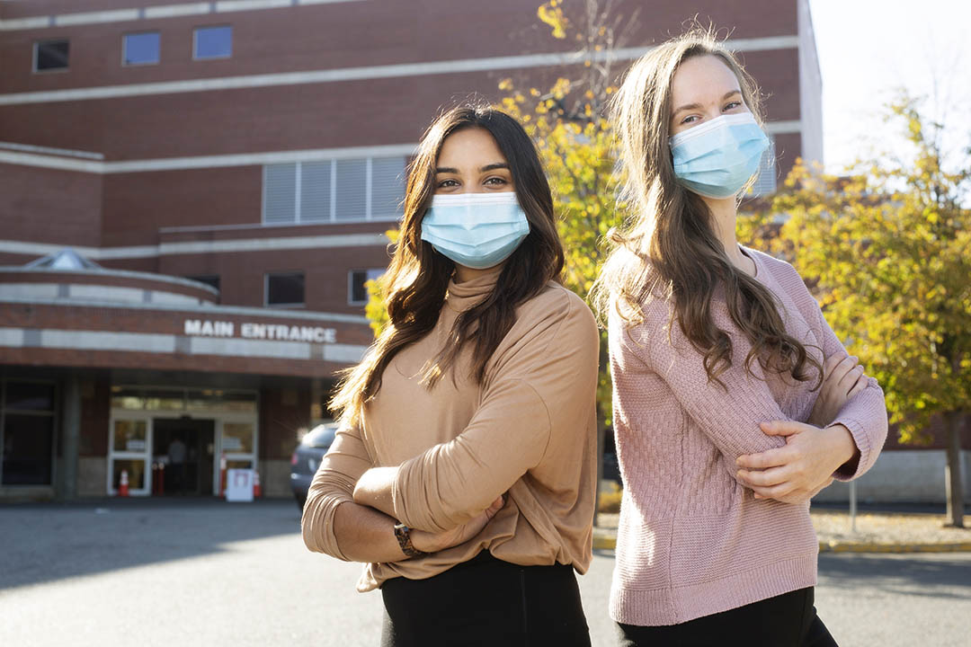 Two students with the University of Saskatchewan College of Medicine pose in front of the hospital in Regina