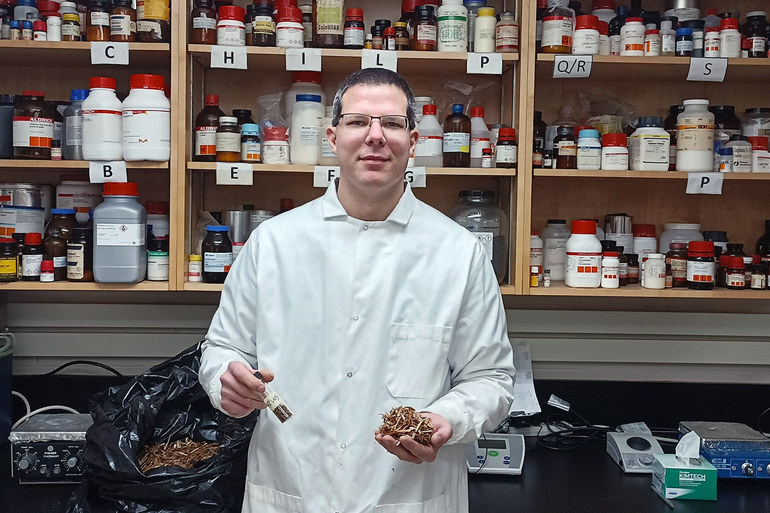 USask PhD student Bernd Steiger, wearing a lab coat and glasses, is standing in a laboratory at the USask campus.