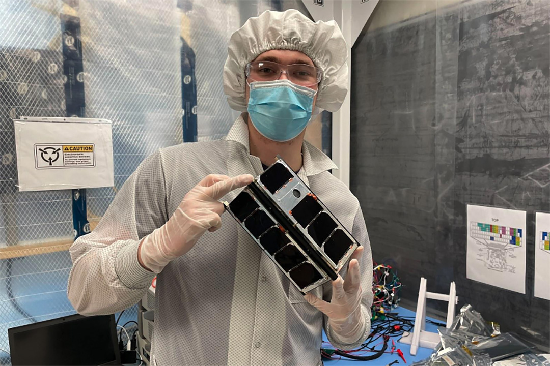 A member of the RADSAT-SK satellite team holds the satellite that will be launched into space. (Photo: Submitted)
