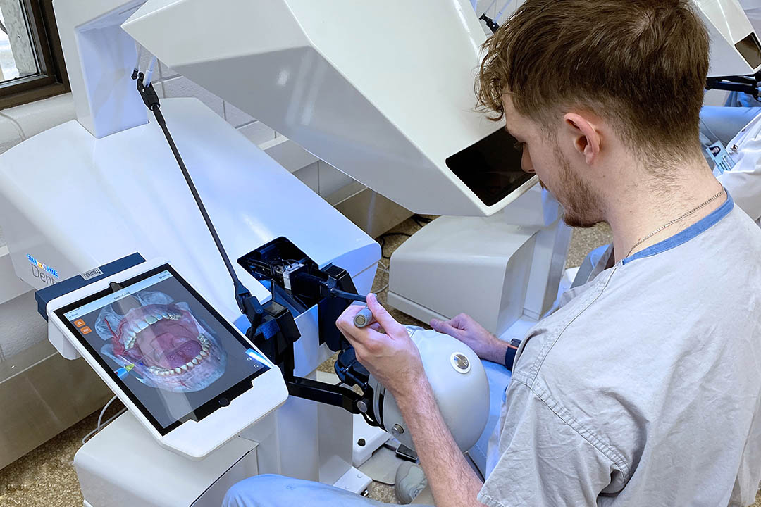 Dentistry student Logan Henriksen performs a procedure on a mixed reality simulator. (Photo: USask College of Dentistry)