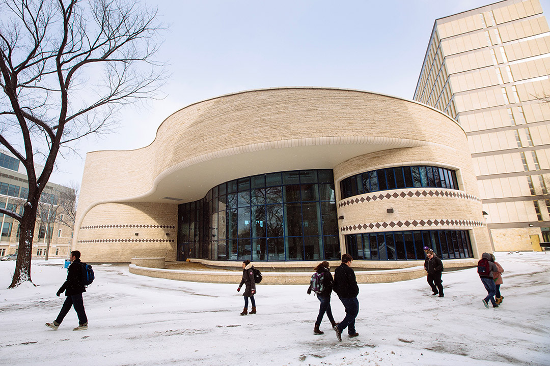 Students walk in front of or near The Gordon Oakes Red Bear Student Centre at the University of Saskatchewan campus.