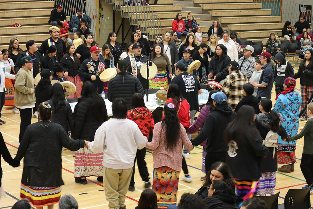 Round dance gathering, featuring a large crowd dancing in a circle