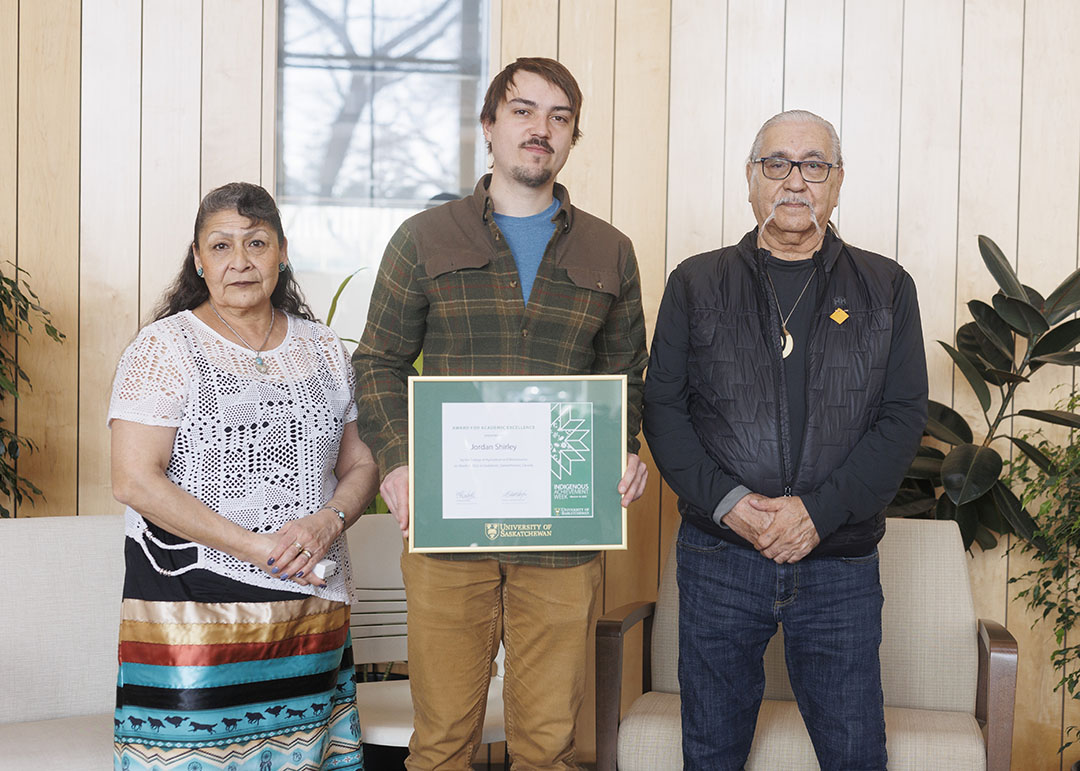 Jordan Shirley receiving his Indigenous Academic Achievement Award from Elders Linda Sanderson and Roland Duquette. (Photo: Dave Stobbe) 