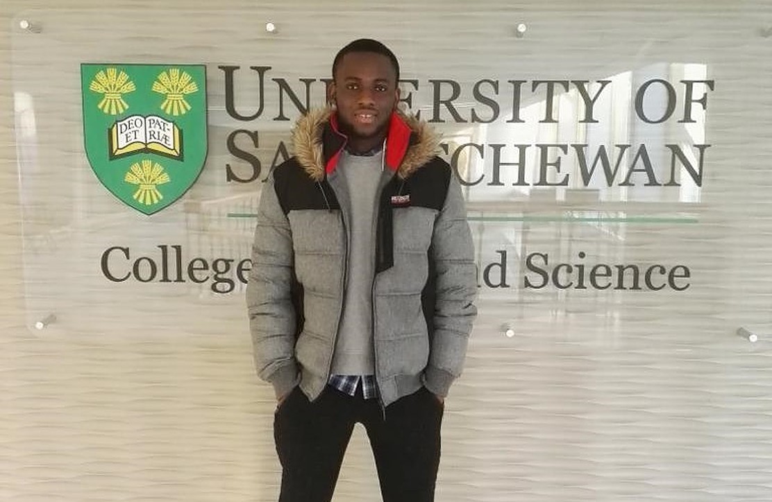Omozojie Paul Aigbogun in front of a University of Saskatchewan sign during his first year on campus in 2017. (Photo: Submitted)