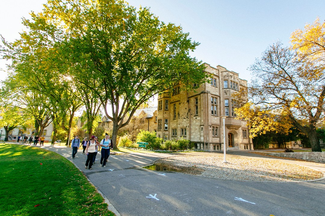 A photo of students walking past Saskatchewan Hall on the USask campus. (Photo: Dave Stobbe)