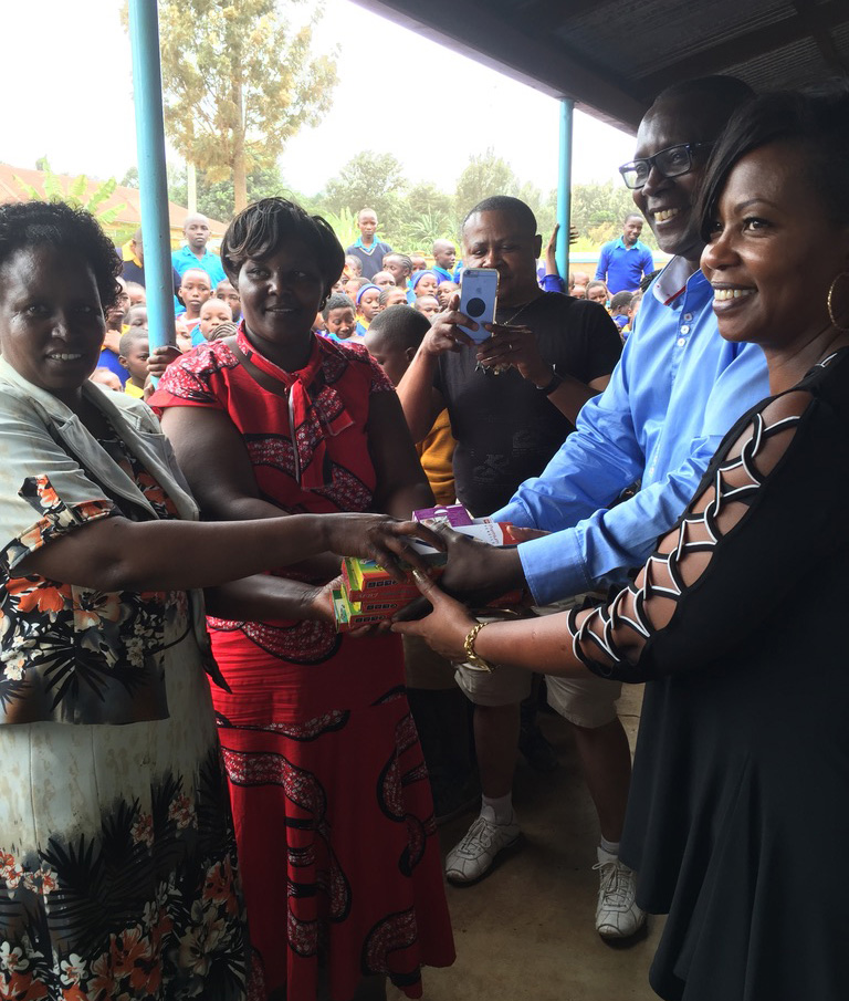 From right, Dr. George Mutwiri (DVM, PhD) and his children George Jr. and Vanessa, as well as Gitonga (at left) present soccer balls to George’s old school in Nkabune Village in Kenya in 2016. 