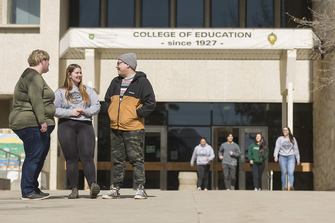 The College of Education building with several students gathered out front