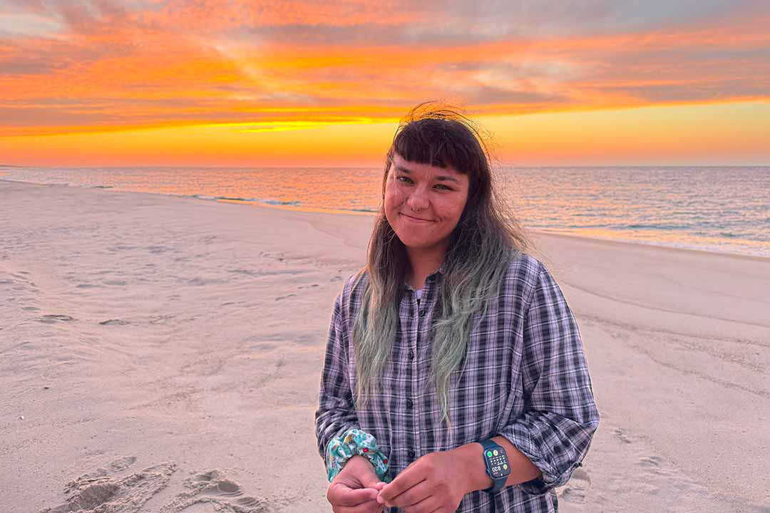 Indigenous USask student Olivia Andres, centre, writes down data about wild horses on Sable Island during her summer research experience. (Photo by PhD student Justine Ammendolia, Dalhousie University)