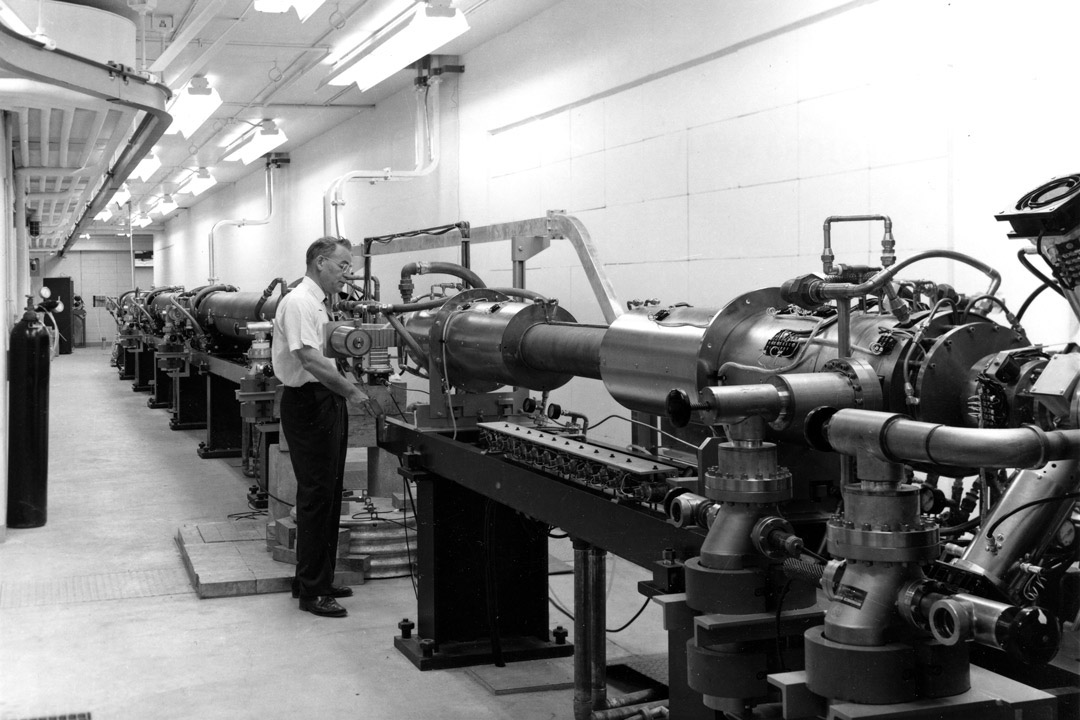 Dr. Leon Katz (PhD), director of the Saskatchewan Accelerator Laboratory, stands next to the linear accelerator in 1964. (Photo: Gibson, University Archives and Special Collections, A-4393)