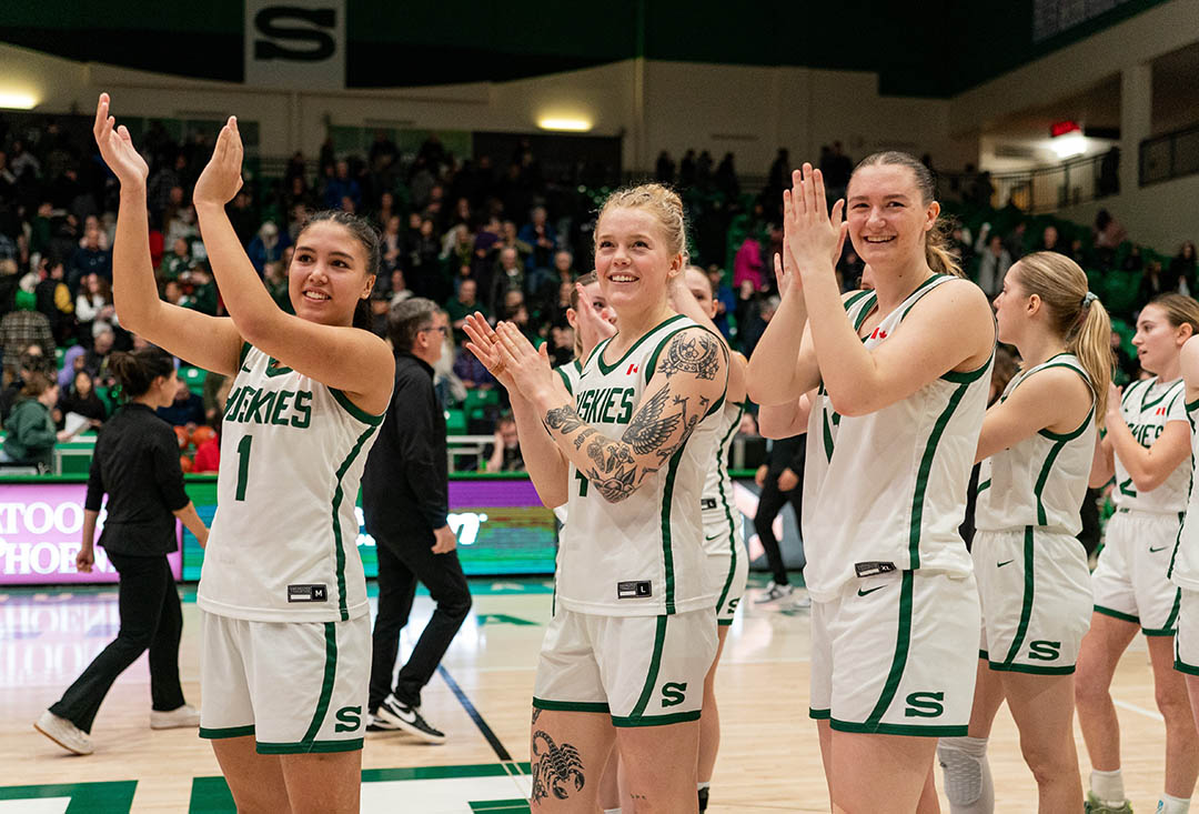 Members of the University of Saskatchewan (USask) Huskie women’s basketball team celebrate their Canada West semifinal victory on Saturday at the PAC. (Photo: Electric Umbrella/Huskie Athletics)