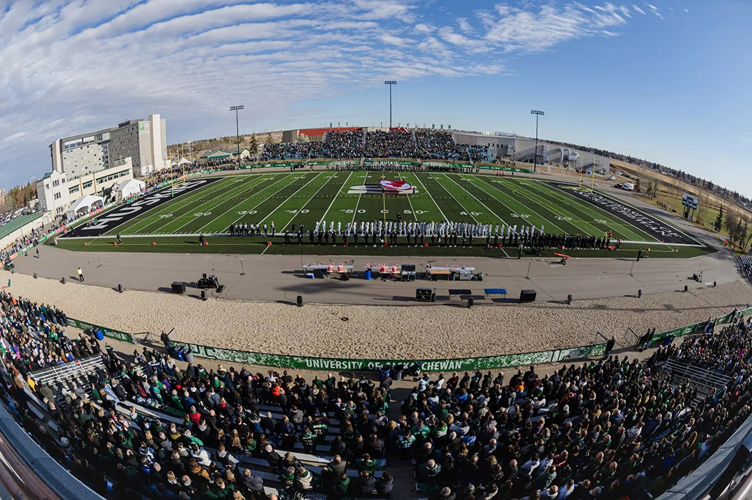 Crowds pack the stands at a football game at Griffiths Stadium on a sunny day at the USask campus.