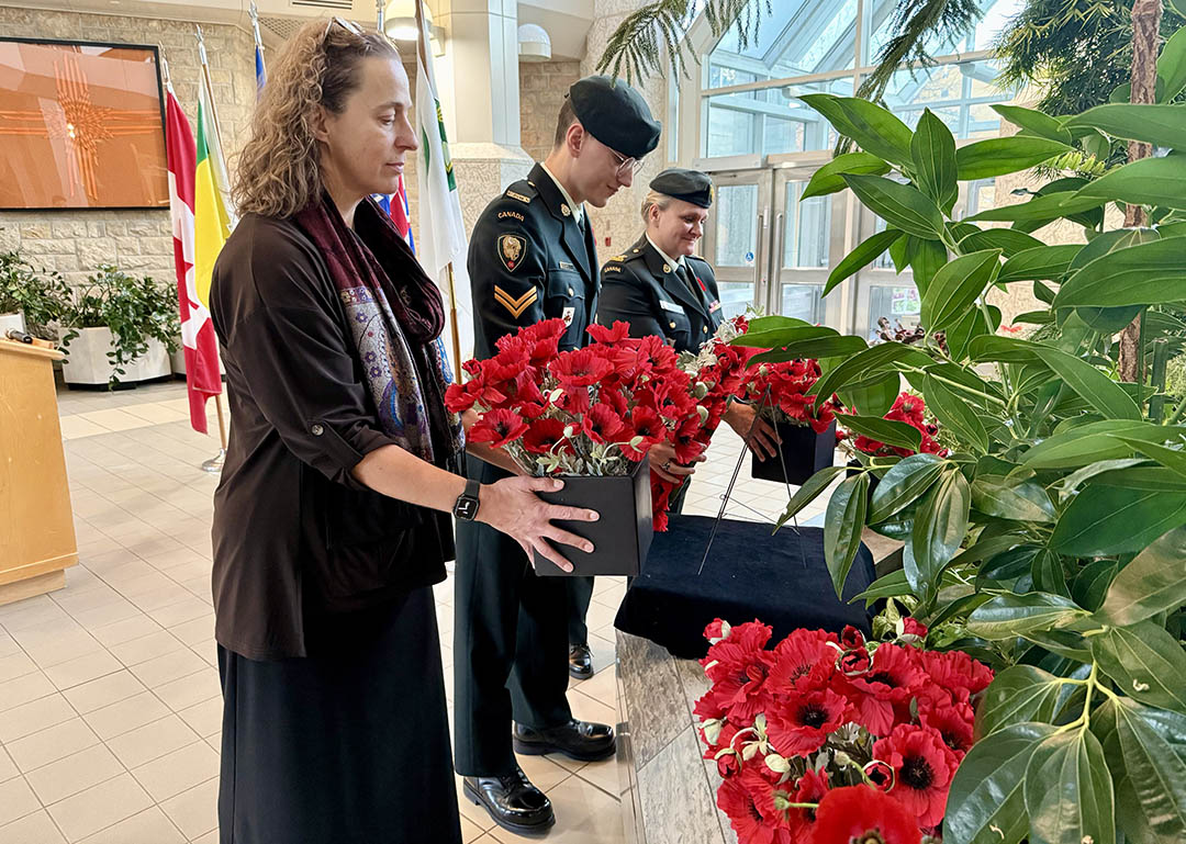 Dr. Angela Bedard-Haughn (PhD), dean of the College of Agriculture and Bioresources (front), Corporal Fikret Ükis (centre) and Major Shelly Bellisle (back) lay a wreath and potted poppies in the Agriculture Building on Tuesday. (Photo: Kira Glasscock)