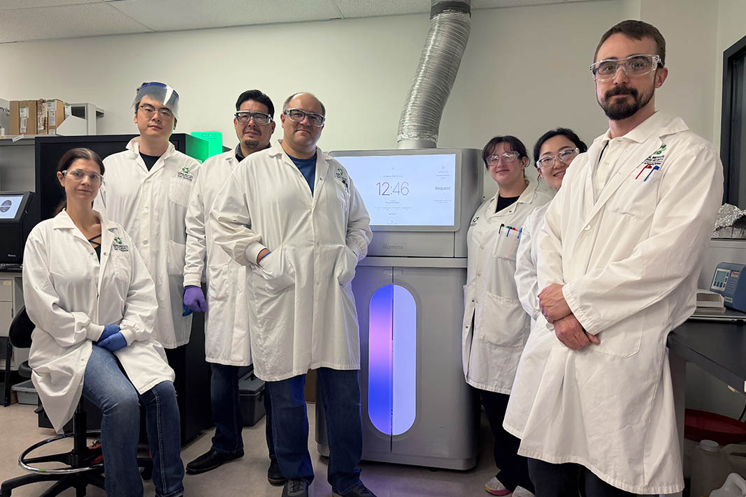Global Institute for Food Security research technicians stand with the new Illumina NovaSeq X Plus genomics breeding technology, acquired with support from PrairiesCan.